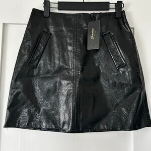 Women’s black faux leather miniskirt with pocket details in the front.